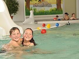 2 Kinder im Flachwasserbecken am Spielen - Wellnessurlaub mit Kindern
